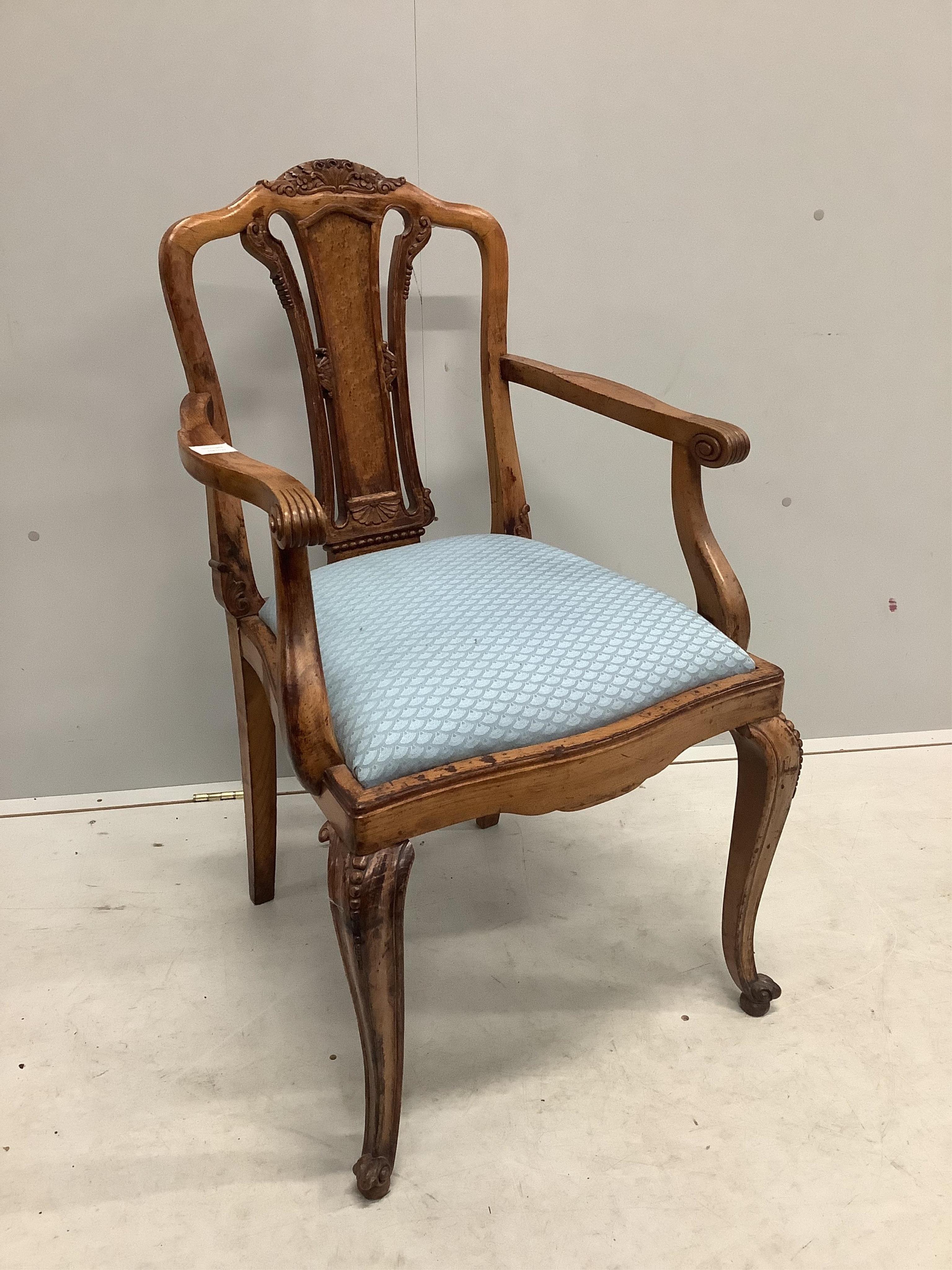 An early 20th century French carved beech and walnut elbow chair, width 56cm, depth 51cm, height 98cm. Condition - fair